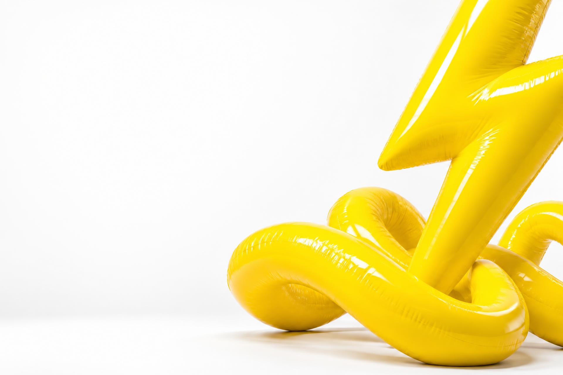 Glossy yellow lightning bolt and looping sculpture